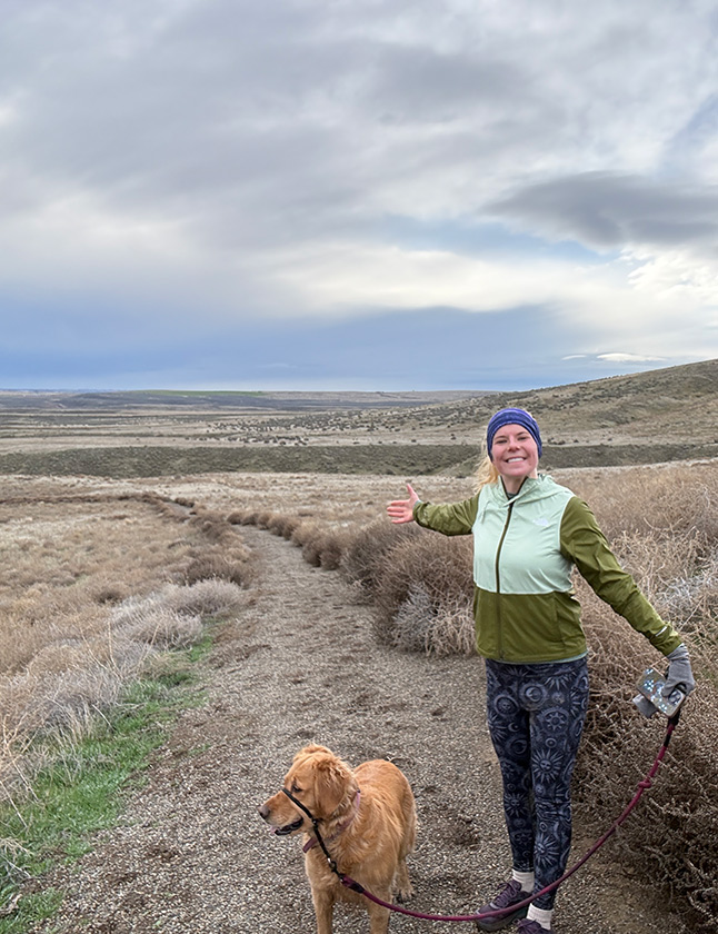 Marina standing on a path near the Oregon Trail near Hagerman, ID, during a run with TIFO office dog Biscuit.